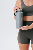 HER 1L insulated water bottle in stone, showcasing the powder-coated matte finish and carry handle lid