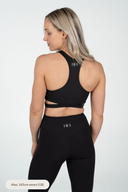 Back detail of the Empower Crop on a small model, highlighting the modern cut-out design and sustainable recycled fabric