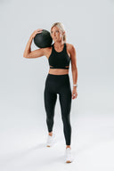 Model wearing the Empower Crop in black, showcasing a sleek high-support fit designed for high-intensity workouts